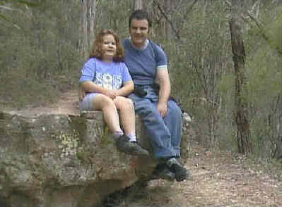Catherine and her dad sitting on a rock in the middle of the old railway.